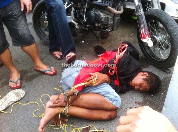 Snatch thief detained by the public. Image from The Borneo Post Online.